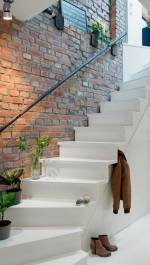 white staircase and rustic brick wall